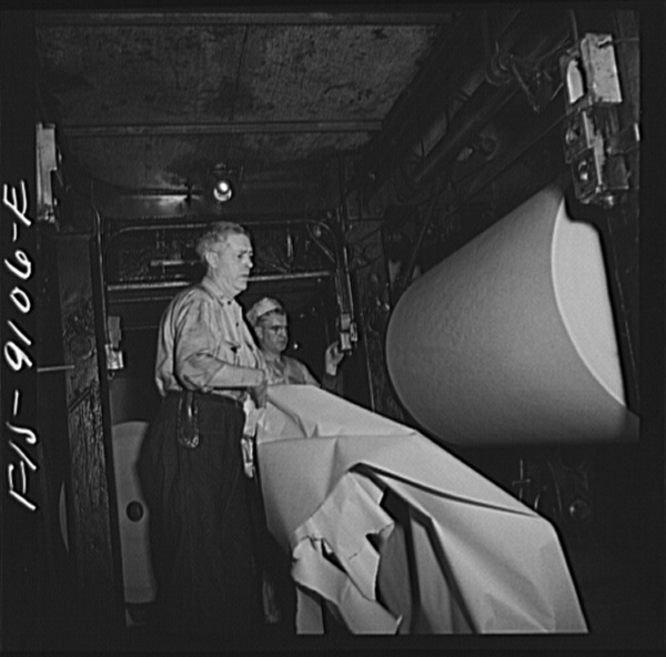 New York, New York. Reel room of the New York Times newspaper. Preparing to thread paper through presses