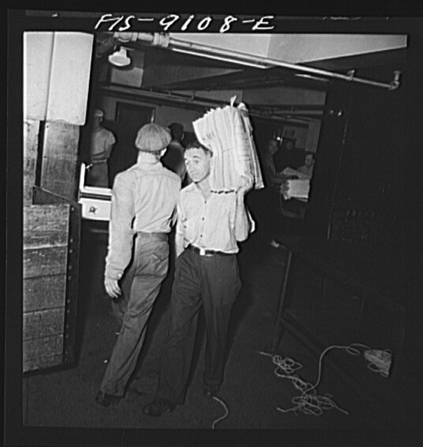 New York, New York. Mailroom of the New York Times newspaper. Bundles of papers are carried to trucks for distribution